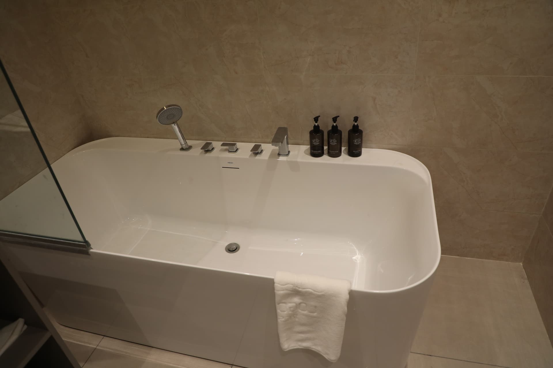 Beige-stone bathroom with soaking tub