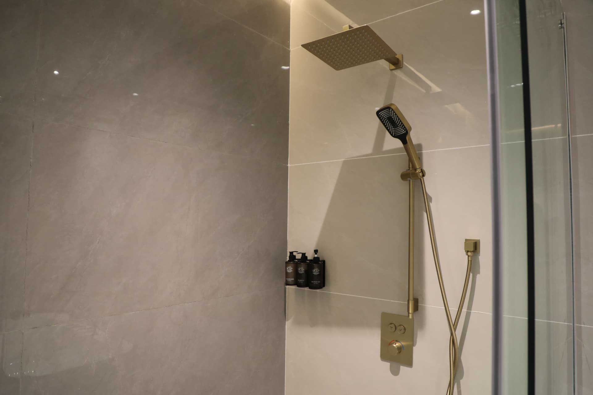 Dark grey marble bathroom with freestanding tub and twin basins